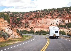 RV driving through curvy desert mountain road