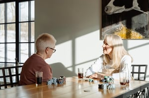 two women speaking at a kitchen table