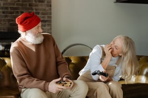 Older couple playing games together inside home