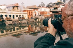 older man taking photos outside
