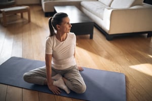 older woman practicing yoga on mat at home