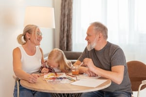 grandparents and grandchild doing art project in well-lit room 