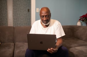 older man sitting down looking at computer screen