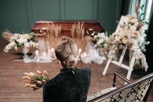 grieving woman approaching coffin at wake 