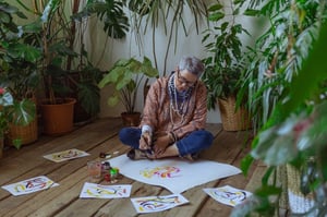 older woman sitting on the floor painting