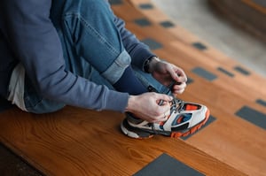 man putting on tennis shoes 