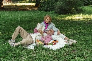 older couple reading together outside during picnic