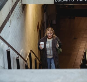 older woman walking up the stairs from the subway