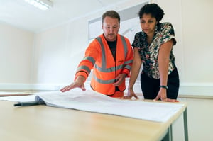 Woman discussing plans with profesional contractor for home renovation