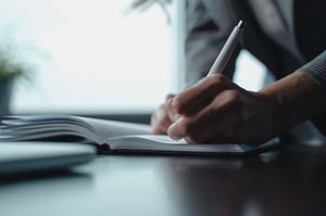 Older woman writing goals in notebook