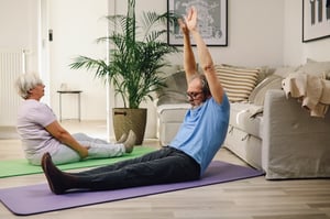 older couple practicing calisthenics at home in living room