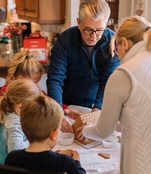 family making gingerbread houses together
