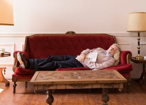 Man sleeping on sofa in well-lit room