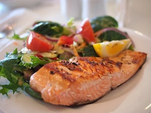 salmon filet on plate with vegetables