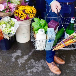 man carrying grocery basket through grocery store