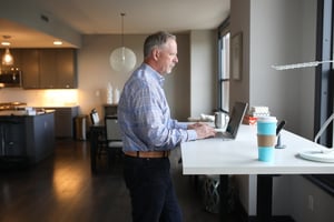 man working at home at standing desk with laptop