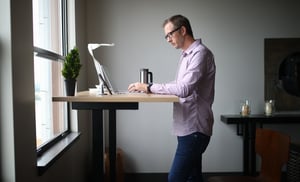 Older man working indoors at standing desk