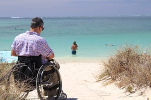 older man in wheelchair at the beach