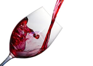 red wine pouring into stemmed wine glass